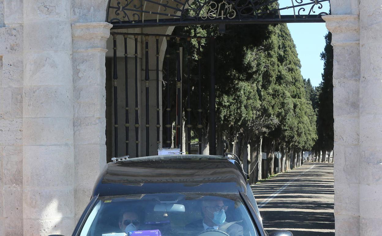 Un coche fúnebre sale del cementerio de El Carmen. 