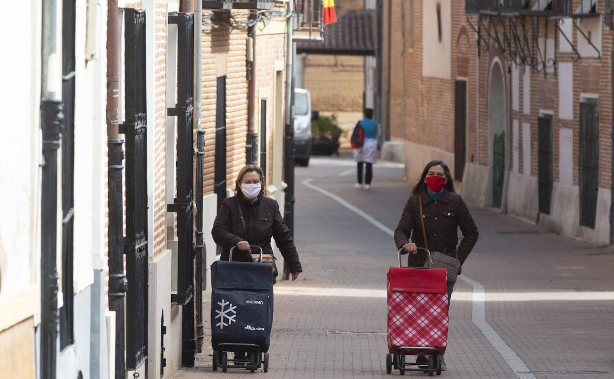 Dos mujeres se dirigen a hacer la compra en Alaejos (Valladolid), una de las zonas que pasará el lunes a la fase 1