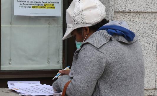 Una mujer cumplimenta el formulario para pedir la ayuda oficial. 