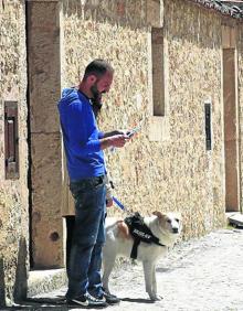 Imagen secundaria 2 - Arriba, David y su hija Vega juegan en la plaza de Navafría. Abaj, Marisa, lotera de Sepúlveda, y un joven saca a a pasear a su perro por las calles desiertas de Pedraza. 