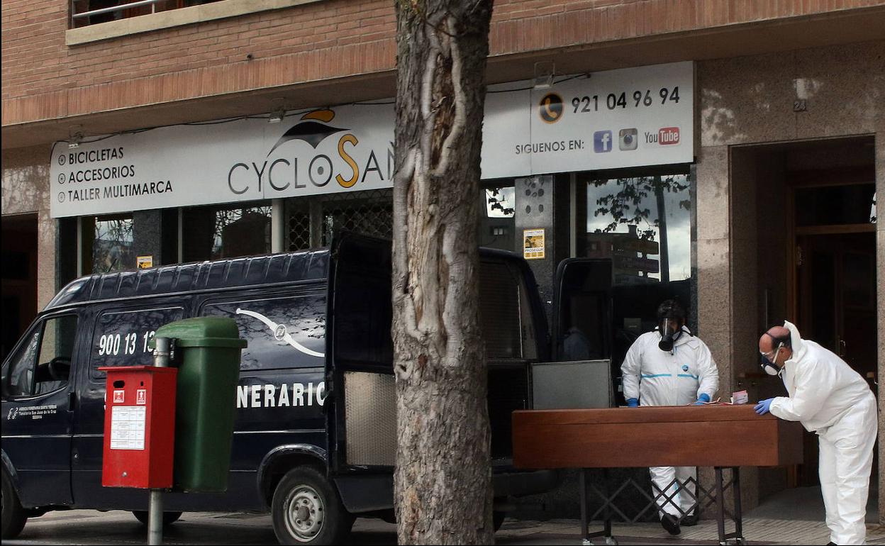 Operarios de la funeraria sacan un féretro durante la crisis del coronavirus en Segovia. 
