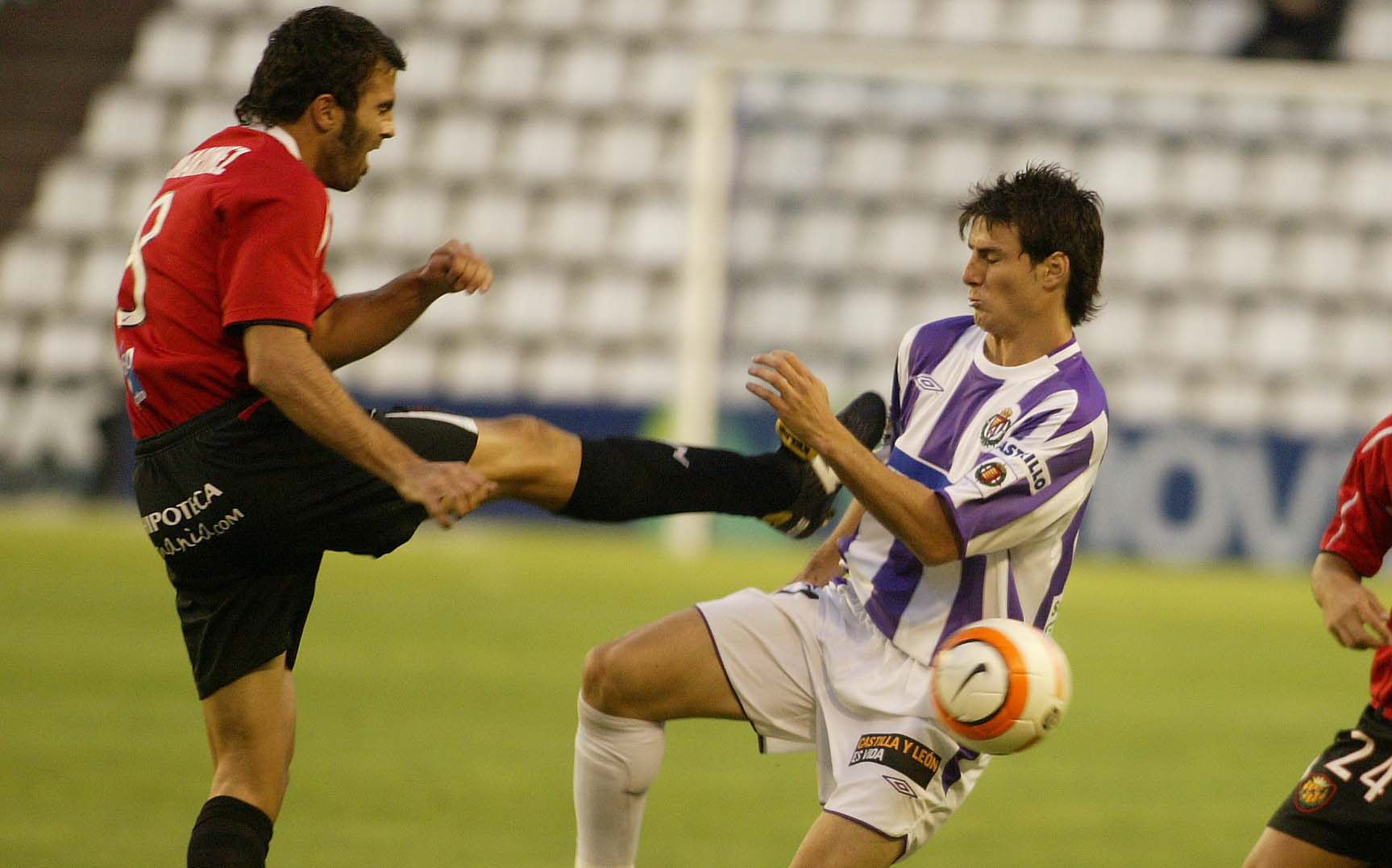 10/09/05 El jugador del Real Valladolid Aduriz (d) recibe la fuerta entrada, con plantillazo incluido, de un defensor del Nástic.