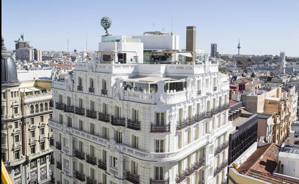 La Gran Vía de Madrid con la escultura del dios Atlas en lo alto de la azotea del hotel NH Collection. 