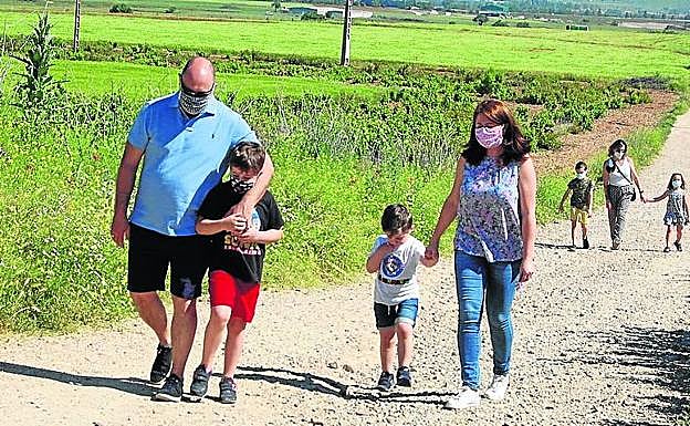 Una familia paseando al completo por el Camino del Río de Cigales.