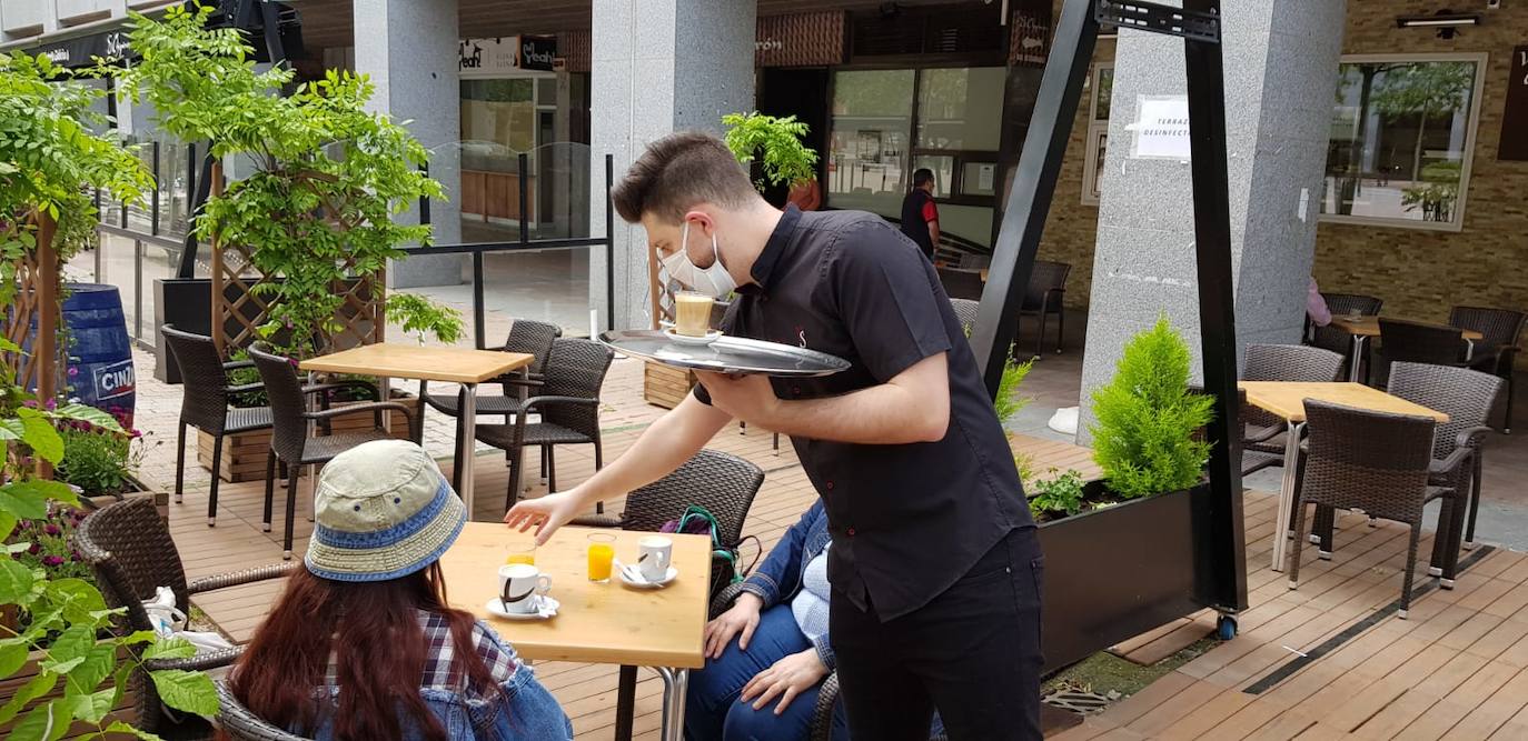 Un camarero sirve un desayuno en una terraza de Parquesol. 