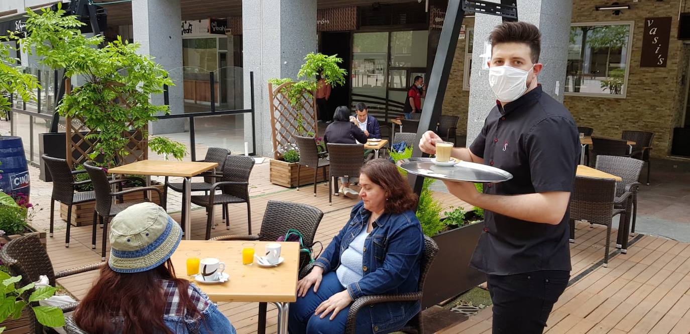 Un camarero sirve un desayuno en una terraza de Parquesol.