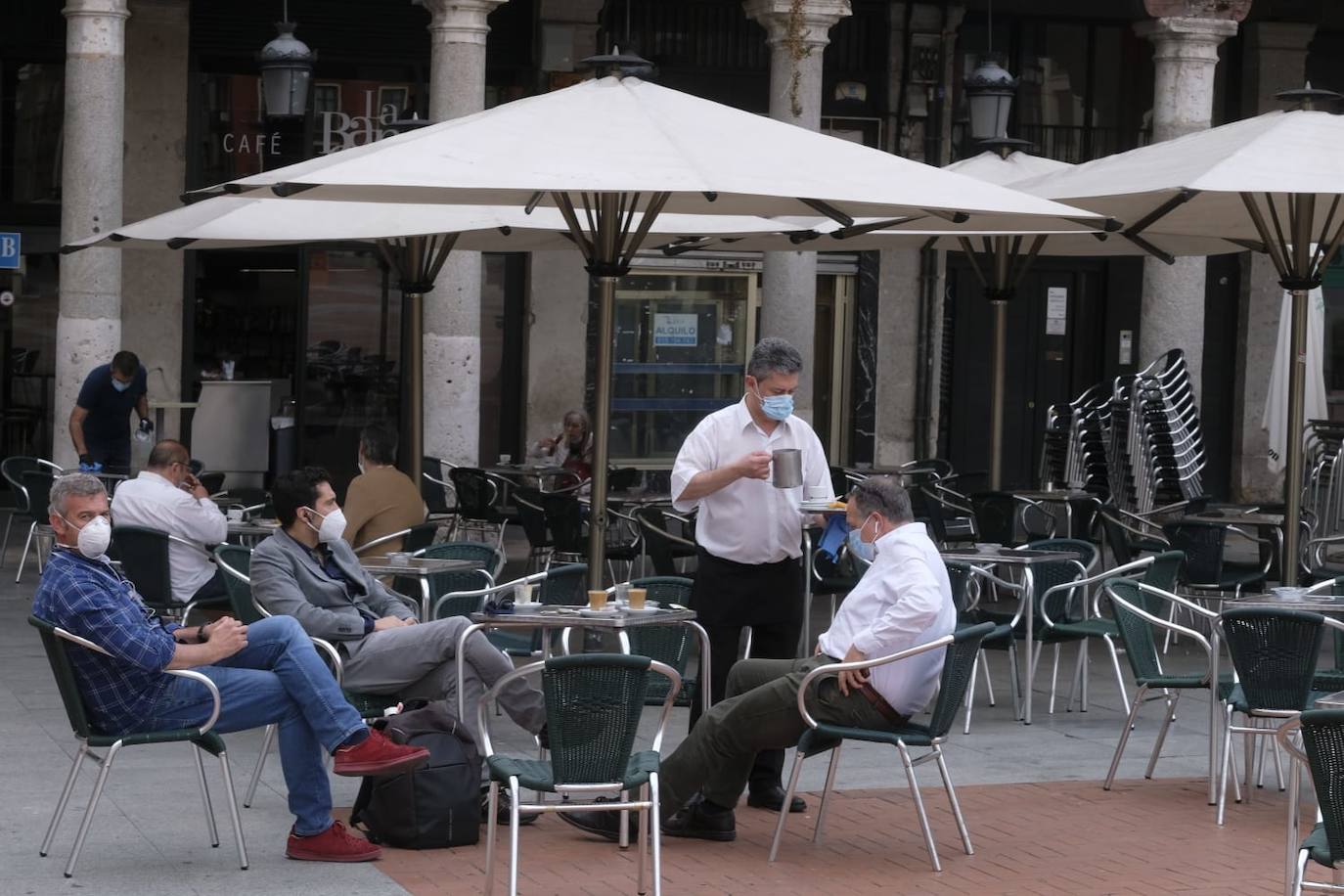 Un camarero sirve a unos clientes en una terraza de la Plaza Mayor 