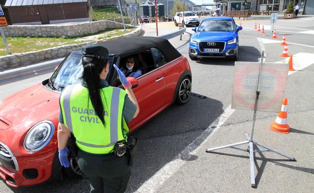 Imagen principal - Distintos momentos del control de la Guardia Civil de Segovia en el alto de Navacerrada, este lunes. 