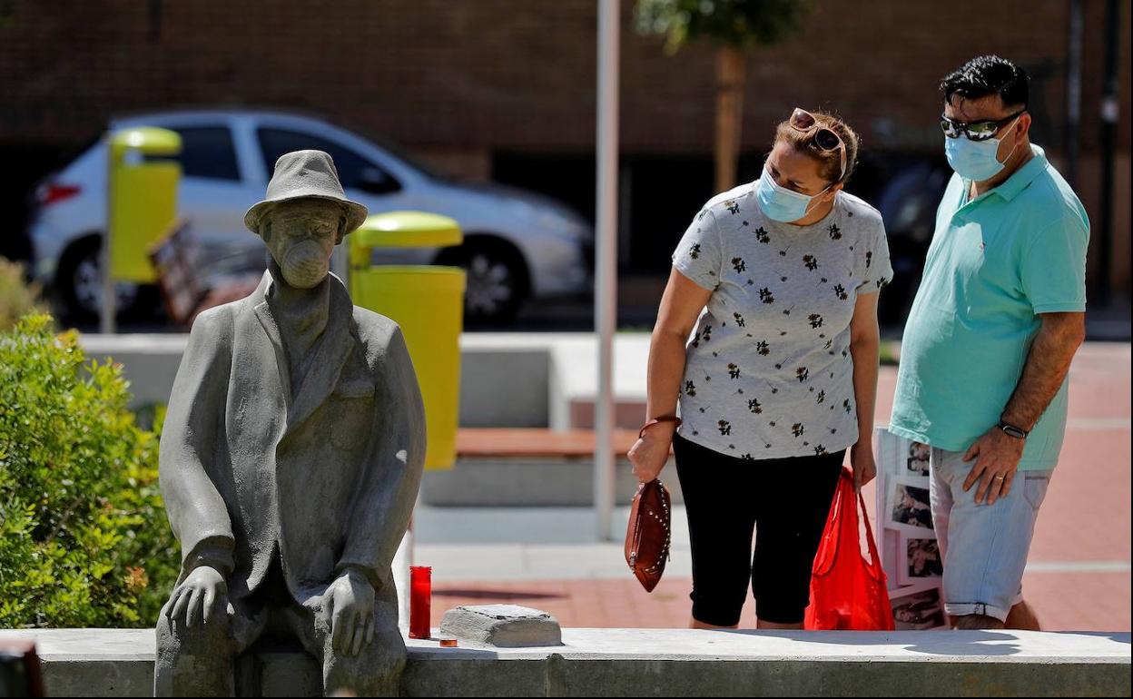 Dos personas observan la escultura dedicada a las víctimas de la covid-19 en un pueblo de Valencia.