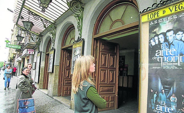 Una aficionada contempla la cartelera del Lope de Vega.