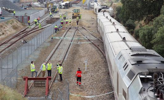 El tren este miércoles sobre la vía mientras los operarios trabajan para despejarlo. 