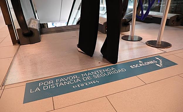 Señal informativa junto a las escaleras mecánicas.