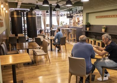Imagen secundaria 1 - Arriba, una camarera atiende a dos clientes en El Trébo. Abajo a la izquierda, cafetería Mercado del Trigo de la calle Regalado. A la derecha, interior del Café Ideal Nacional, en la Plaza Mayor. 