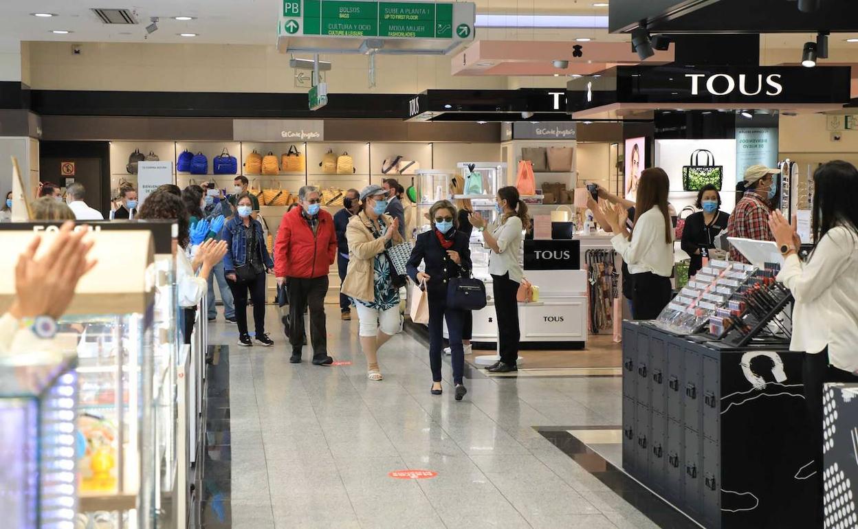 Trabajadores de El Corte Inglés aplauden a sus clientes en la repaertura del centro comercial. 