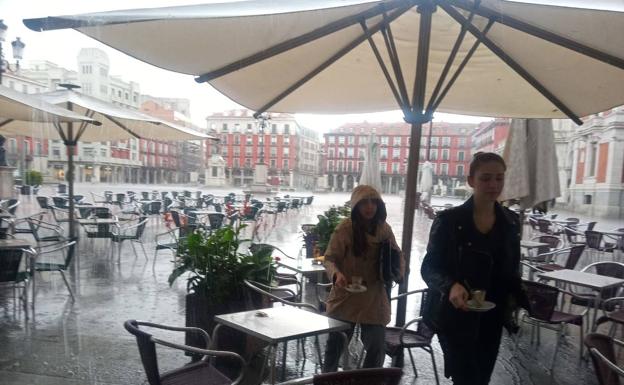 Un par de clientas recogen sus cosas de una mesa en la Plaza Mayor. 