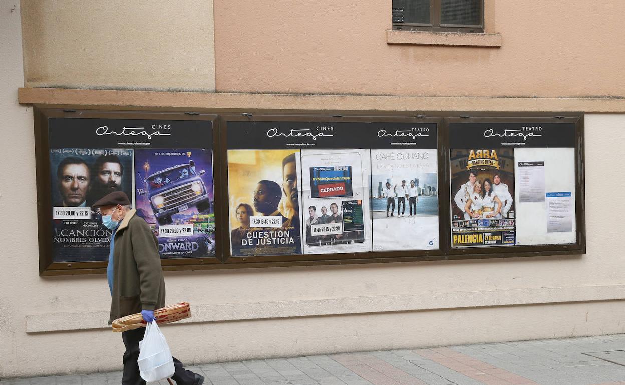 Un hombre pasa delante de la cartelera del cine Ortega, cerrado durante la pandemia. 