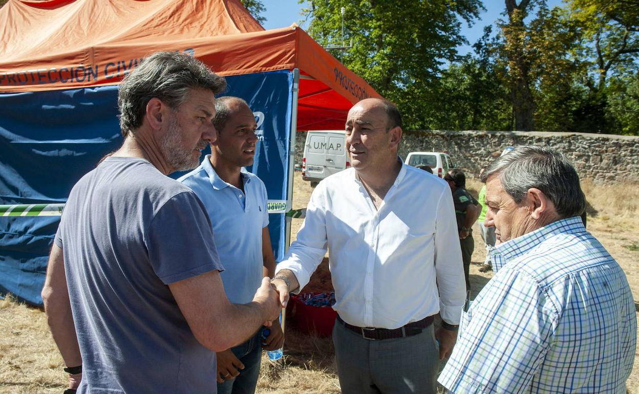 El exalcalde de La Granja, José Luis Vázquez (izquierda), estrecha la mano del presidente de la Diputación, Miguel Ángel de Vicente, en el campamento base durante las tareas de extinción del incendio. Óscar Costa