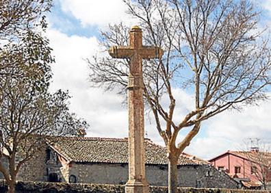 Imagen secundaria 1 - Arriba, verja de entrada a la iglesia de la Natividad; uno de los cruceros situados por la localidad y la vieja olma tallada con la Casa Consistorial al fondo.