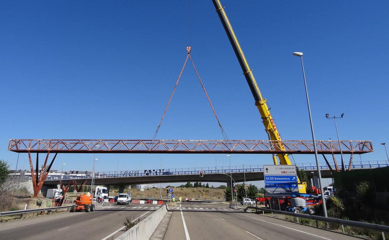 La grúa retira la pasarela peatonal de la carretera de Segovia. 