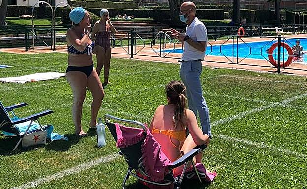 Un técnico advierte a dos usuarias de que no se pueden utilizar sillas o tumbonas en las instalaciones. 