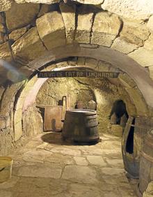 Imagen secundaria 2 - Arriba, Plaza Mayor de Fermoselle vista a través de un arco. Al fondo, la iglesia de Nuestra Señora de la Asunción; Detalle de la reja de un balcón e interior de una bodega subterránea. 
