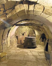 Imagen secundaria 2 - Arriba, Plaza Mayor de Fermoselle vista a través de un arco. Al fondo, la iglesia de Nuestra Señora de la Asunción; detalle de la reja de un balcón e interior de una bodega subterránea.