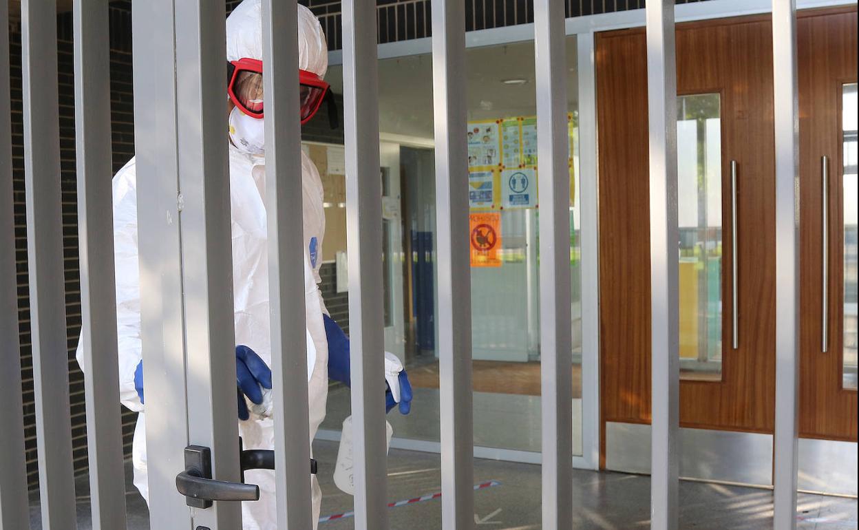 Un bombero desinfecta la entrada de la escuela infantil Cres Sanz.