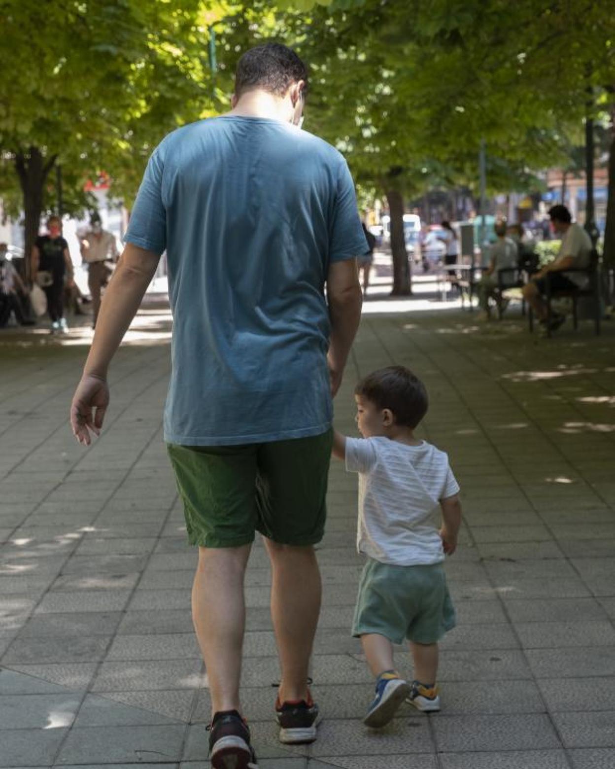 Un padre pasea con un niño por una calle de Valladolid. 