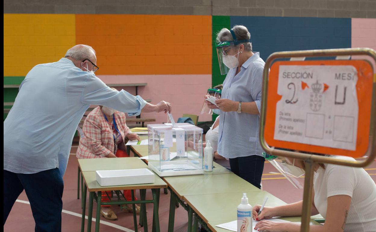 Un elector de Burela deposita su voto manteniendo la distancia.