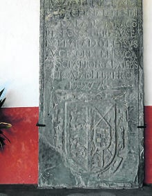 Imagen secundaria 2 - Arriba, crucificado tardo gótico, de madera policromada, junto a varios cuadros; Artesonado que cubre la capilla mayor de la iglesia de San Vicente y lápida de 1597 que se encuentra en el pórtico de la iglesia. 