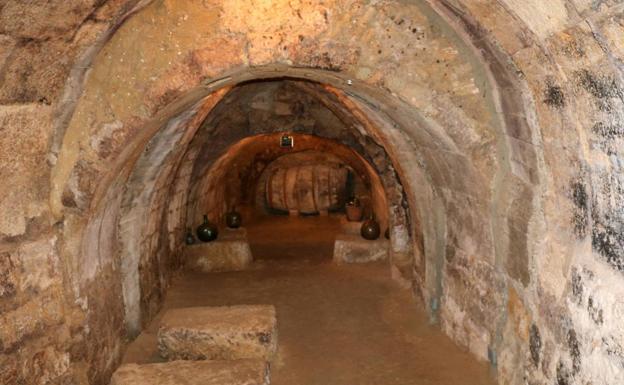 Imagen principal - Pasadizos hechos en piedra de sillas y abovedados que discurren bajo varios tramos de casas de Astudillo y a los que se ha dado valor defensivo, hoy se utilizan en muchos casos como bodega. Sobre estas líneas, edificio del Ayuntamiento de Astudillo, con su archo bajo el que pasa una de las calles de la localidad y torre de la Puerta de San Miguel, único tramo de una de las entradas de la vieja muralla que en su día fue utilizada como cantera pública. 