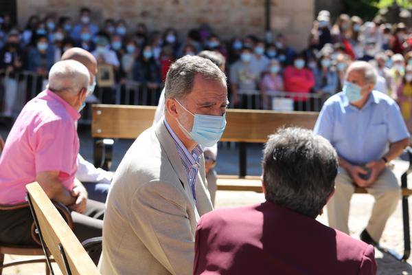 El Rey conversa con un grupo de personas mayores en la plaza de Vinuesa