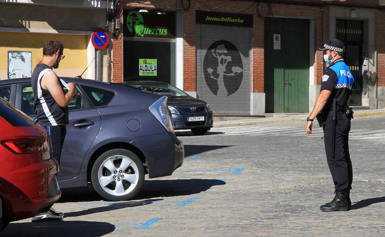 Un agente de la Policía Local llama la atención a una persona para que se ponga la mascarilla..