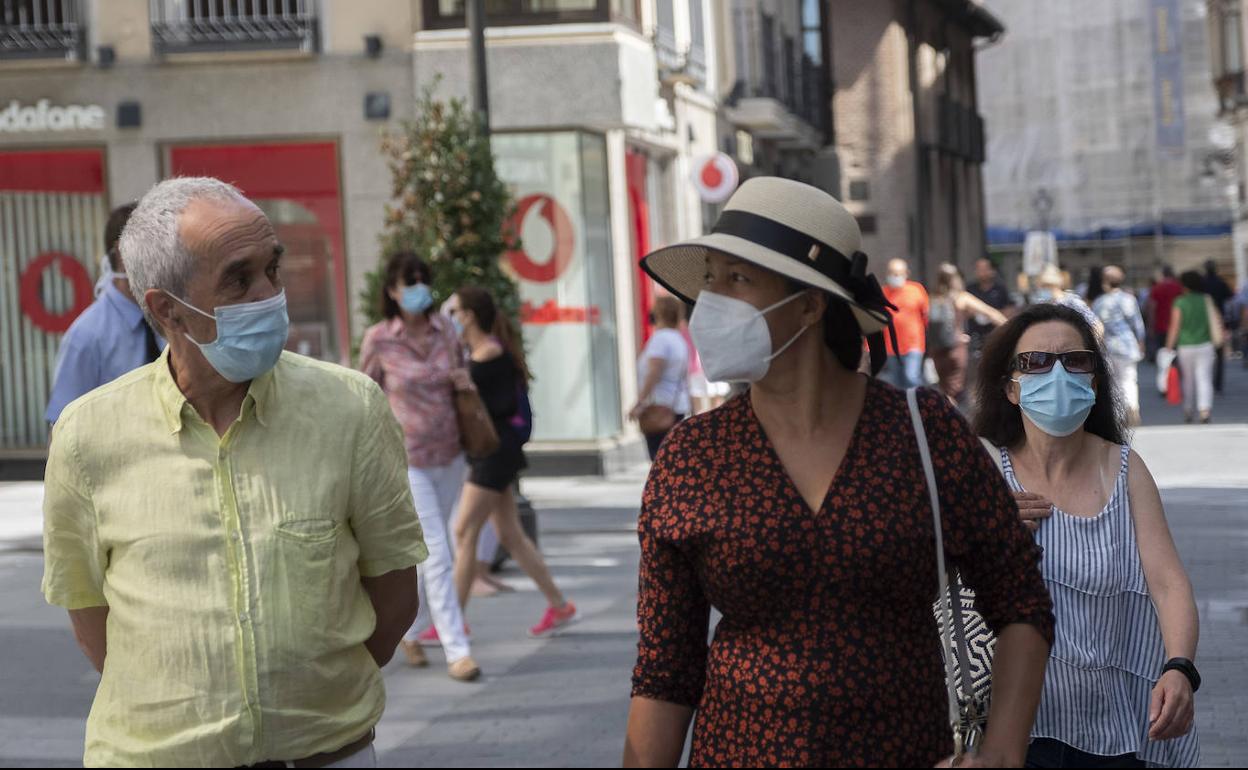 Ciudadanos caminan por las calles de Valladolid con la mascarilla puesta. 