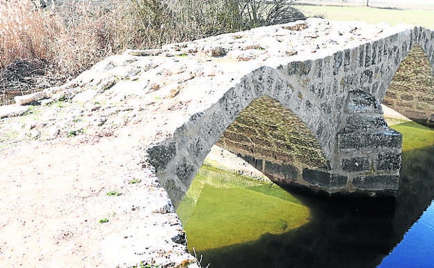 Imagen principal - Arriba, puente romano; escultura en la plaza Segisama y ayuntamiento de Sasamón. 