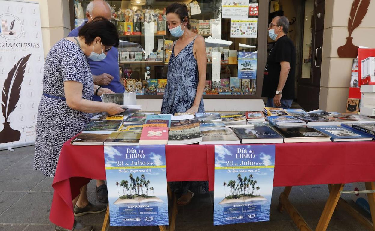 Un grupo de personas contempla el expositor de la librería Iglesias en la Calle Mayor.
