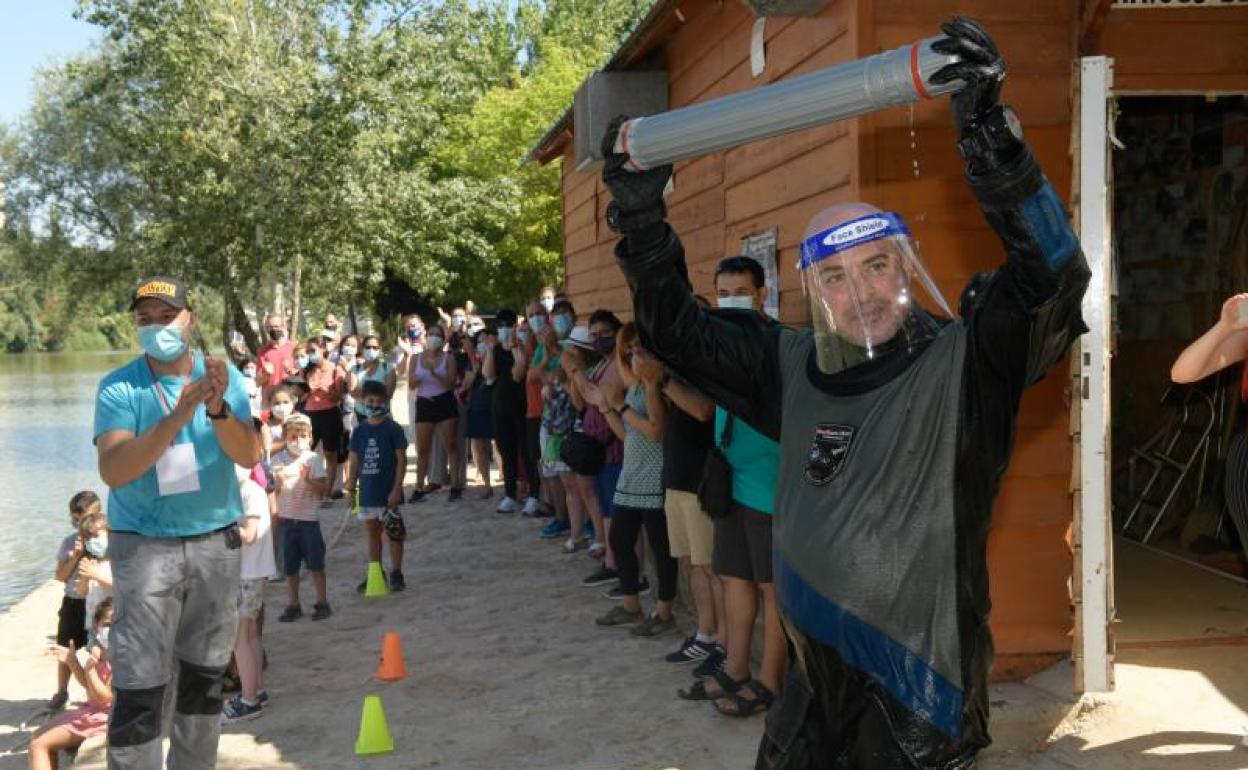 El buzo Javier Marqués muestra la baliza rescatada del río.