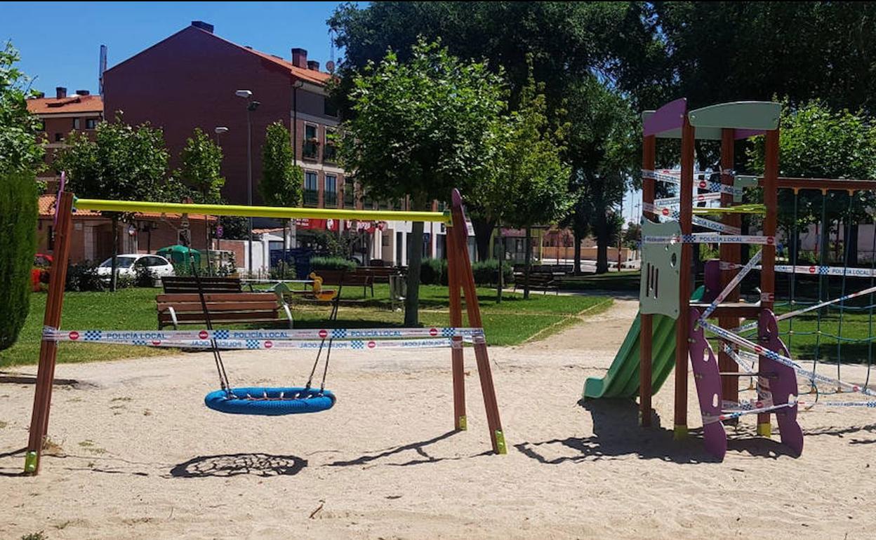 Precintos policiales en el columpio y el tobogán de un parque de La Cistérniga.