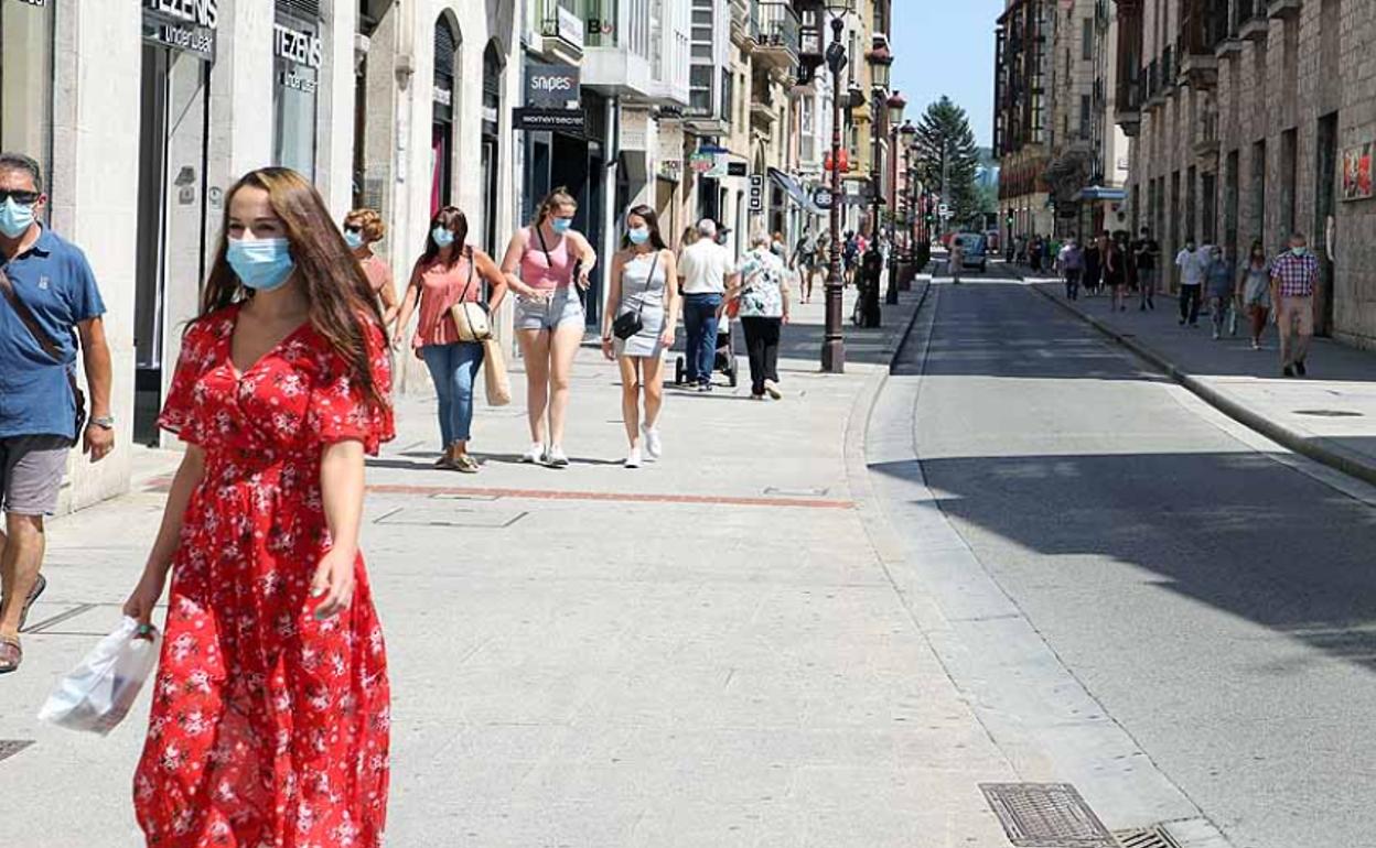 Gente con mascarilla caminando por las cales de Burgos.