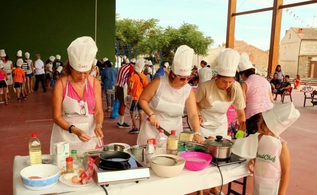 Imagen principal - 'Rural chef', una de las actividades del año pasado. Abajo, reparto de bollos y naranjas en la fiesta de la Virgen de los Remedios y una imagen de la excursión que realizaron todos los vecinos a Santiago de Compostela. 