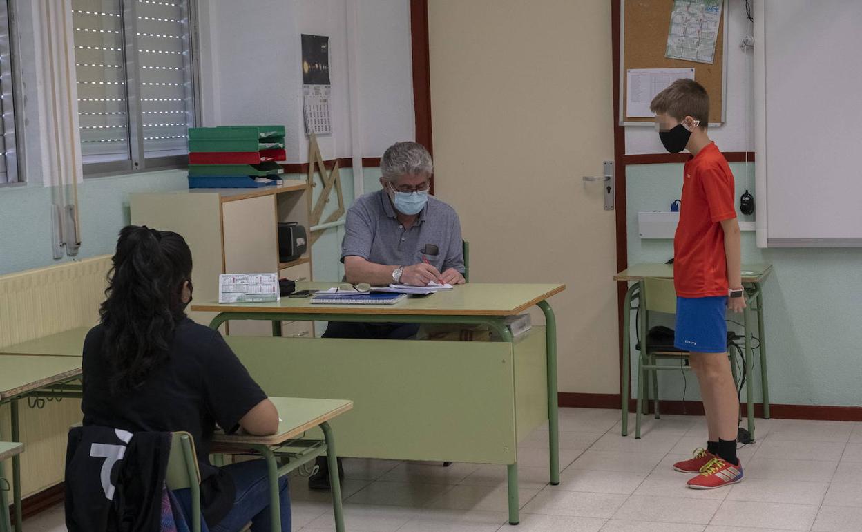 Un profesor atiende a varios alumnos este verano. 