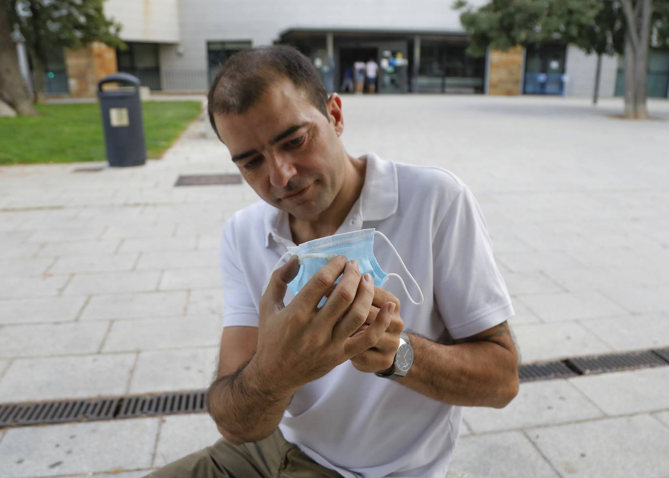 José Luis Saiz coloca su clip sobre una mascarilla frente al centro de salud de La Puebla.