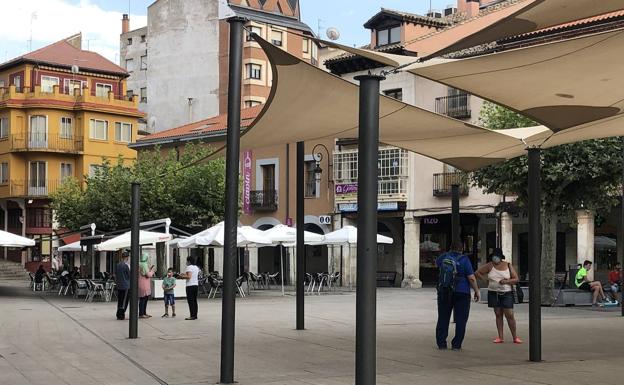 Imagen principal - Imágenes de las calles de Aranda, con pocos vecinos y comercios cerrados.