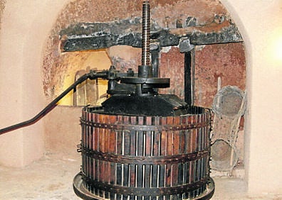Imagen secundaria 1 - En la parrte superio, bajada a una bodega mucenteña; prensa vertical en el Museo del Vino y camino de piedra entre varias bodegas.