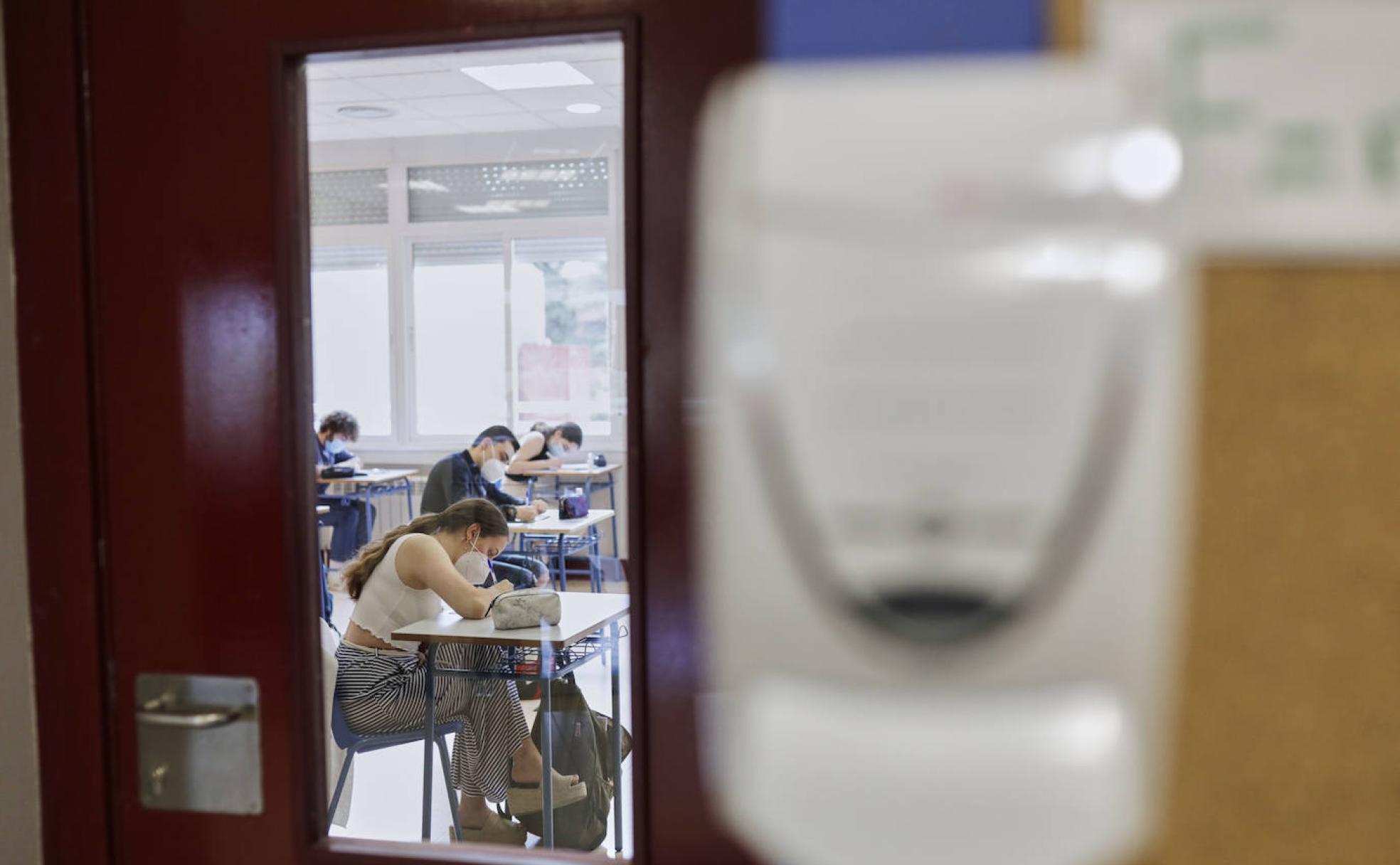 Alumnos de Bachillerato, durante una clase para preparar la EBAU, el pasado mes de mayo, con mascarilla y disponesador a la entrada de clase. 