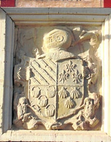 Imagen secundaria 2 - Arriba, vista panorámica del pueblo; altar mayor de la iglesia de San Pedro y escudo incrustado en la pared de una de las casas del pueblo. 