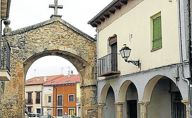 Imagen principal - Arriba, arco de entrada a la Plaza Mayor de Pesquera de Duero; debajo, relieve de la Epifanía y Cristo del siglo XVII, en la ermita del Santo Cristo.