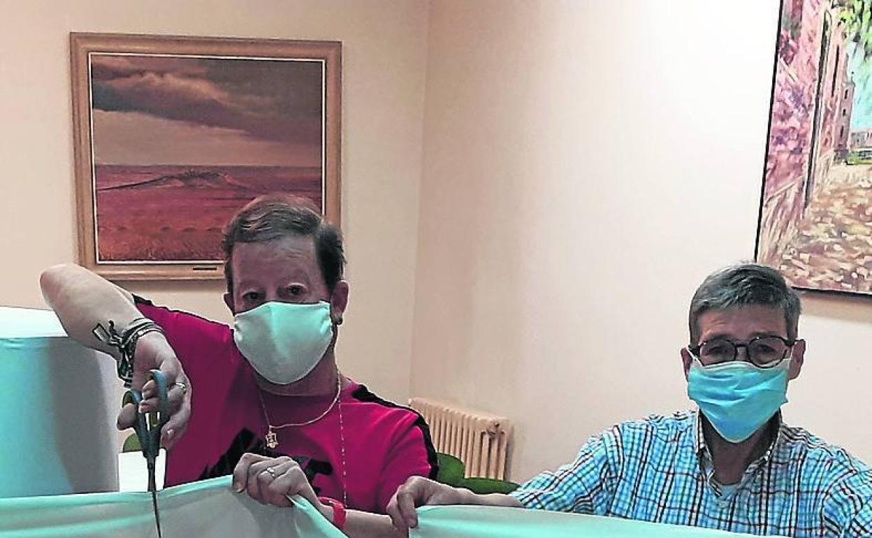 Voluntarios cortan la tela para las mascarillas.