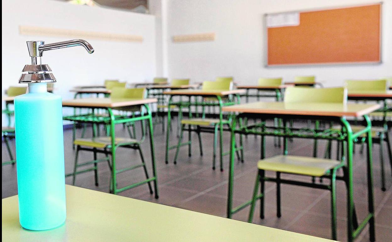 Vista de un dispensador de gel hidroalcohólico en un aula.