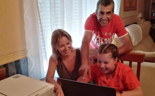 Aitana, junto a sus padres, con el nuevo ordenador. 